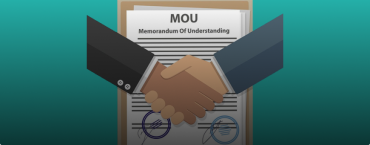 A picture of hands shaking hands and a memorandum in the background.